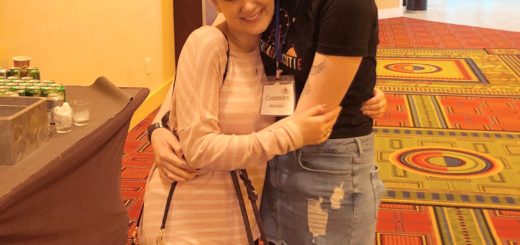 casey and cassandra standing in a hallway with their arms around each other, smiling, march 2018