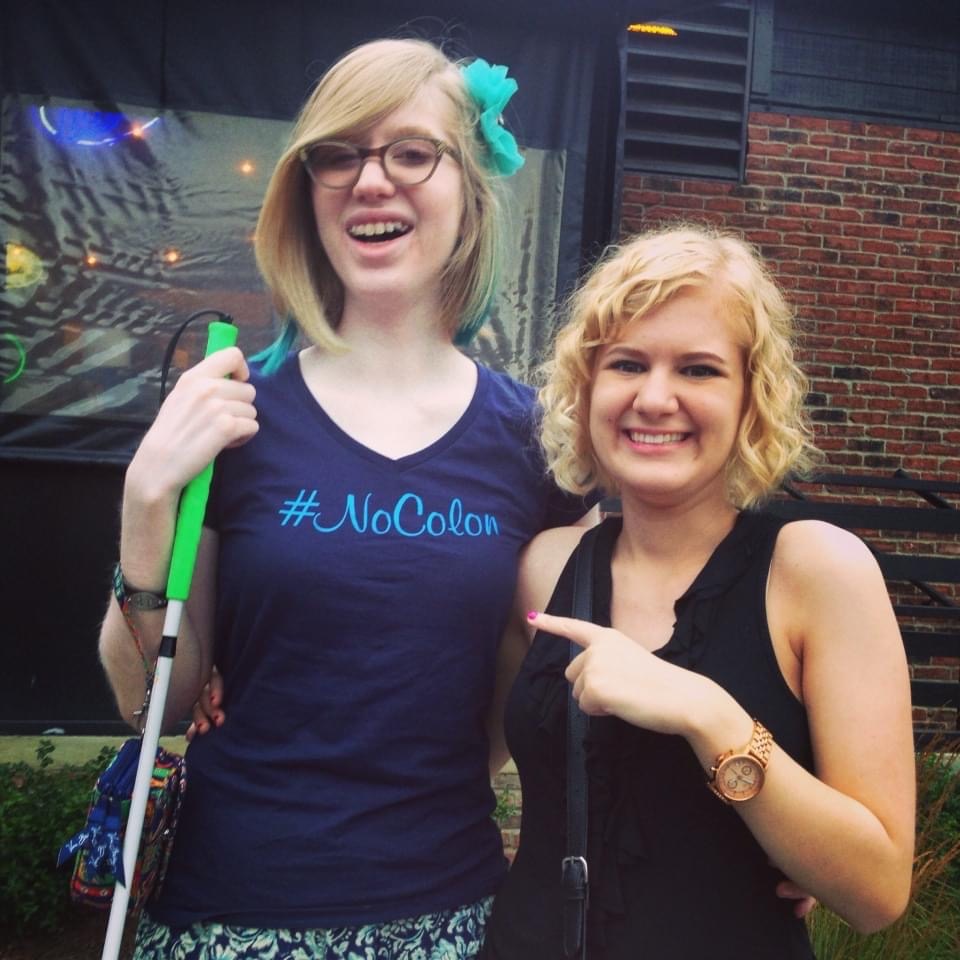 casey pointing to cassandra's shirt which says "hashtag no colon" as cassandra smiles broadly, july 2015