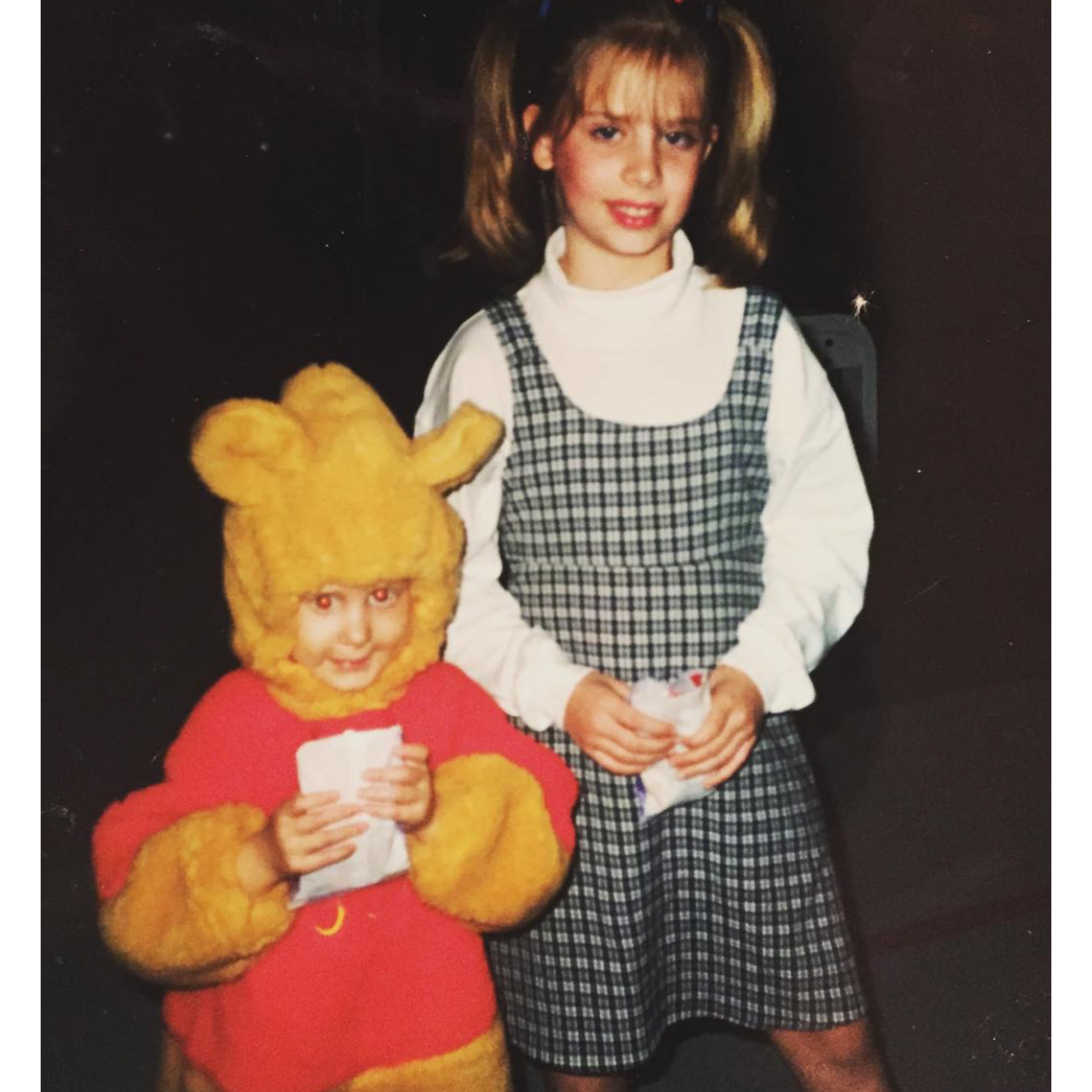 little casey as winnie-the-pooh, she looks up shyly with her sister lynley dressed as baby spice behind her