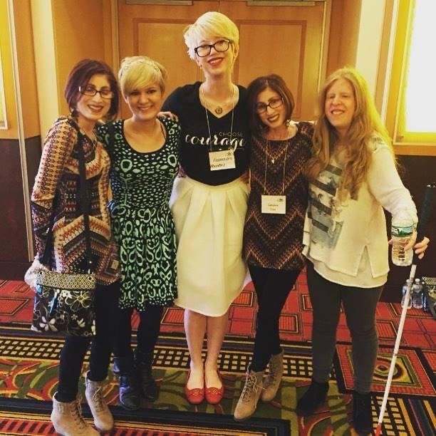 photo of five women with HPS, including case and cass in the middle. from left to right, a brunette with a bob, case sporting a light blonde pixie cut, cass with a platinum blonde pixie, an identical twin brunette, and a woman with long, ashy blonde hair holding a white cane