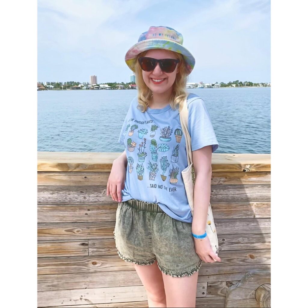 casey smiles on a pier on the beach