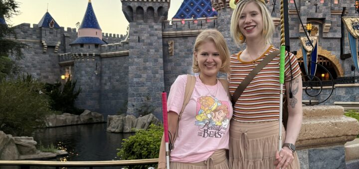 case and cass pose in front of the sleeping beauty castle in disneyland. they smile and wear matching beige tulle miniskirts