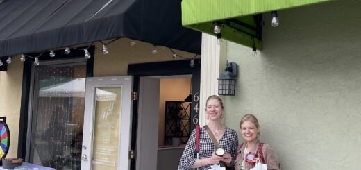Case & Cass smile outside Worthington Candle Works, standing beside the shop’s open doorway holding candles in jars and white shopping bags